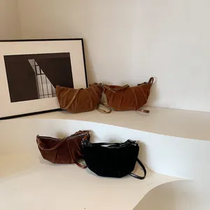 Borse croissant minimaliste in pelle scamosciata opaca nera e marrone su scale bianche