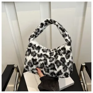 Close-up of black and white leopard print plush handbag with soft faux fur texture