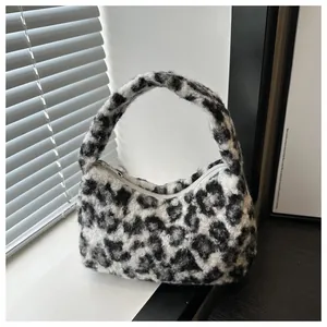 Close-up of soft leopard print plush fabric and zipper closure on a small hobo bag