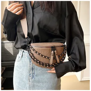 Détail du sac bandoulière marron à motif crocodile et doubles chaînes en métal noir