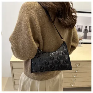 Chic black underarm bag featuring unique textured quilting shown in a lifestyle setting