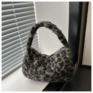 Detail of plush faux fur shoulder bag with black and grey leopard pattern and zip closure