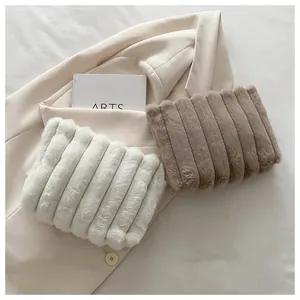 Detailaufnahme der flauschigen Kunstpelz-Clutch mit vertikalem Streifenmuster in Beige