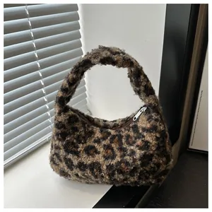 Detailed close-up of fluffy leopard print plush fabric and metal zipper on tote bag