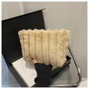 Detailansicht der beigen Kunstfell-Clutch mit vertikalem Plissee und weichem Plüschmaterial
