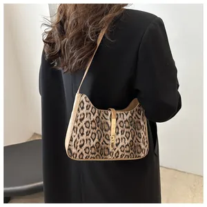 Sac sous le bras à imprimé léopard avec boucle dorée sur un mannequin pour un look rétro