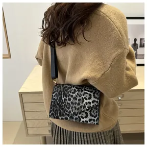 Gros plan du sac bandoulière léopard avec large sangle en nylon porté par un mannequin