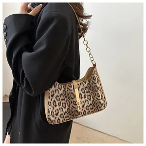 Détail du sac léopard avec boucle dorée et bandoulière en chaîne et cuir