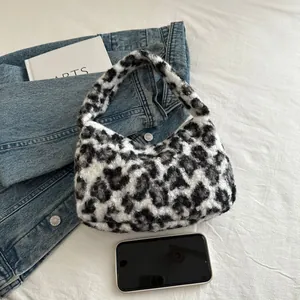 Faux fur leopard print tote bag with soft texture shown with denim jacket and phone
