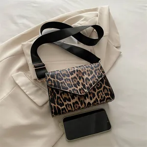 Petit sac carré léopard vintage avec large bandoulière et détails dorés sur un blazer