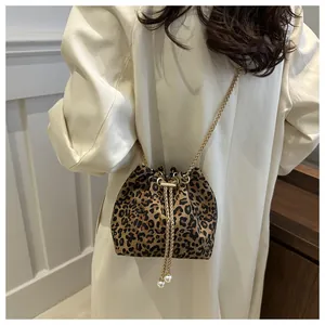 Detalle del bolso saco con estampado de leopardo, adornos de perlas y cadena dorada