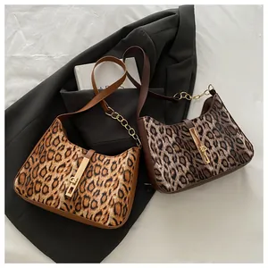 Détail de sacs léopard avec bandoulières en chaîne dorée sur tissu élégant