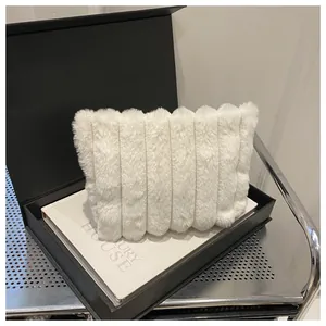 Nahaufnahme der weißen Plüsch-Clutch aus Kunstpelz mit weicher Textur in einer Box