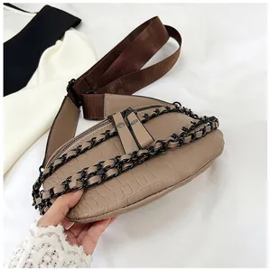 Détail de la texture crocodile et de la chaîne noire sur le sac de couleur kaki