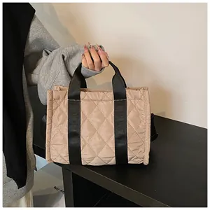 Vue détaillée du sac cabas en nylon matelassé avec des poignées en sangle noires