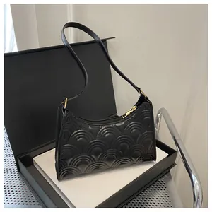 Close-up of black quilted underarm bag with golden zipper and textured PU leather