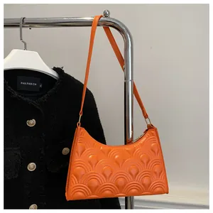 Detailed macro view of the bright orange embossed wave texture on a stylish PU leather bag