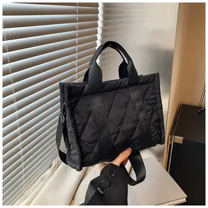 Détail du sac cabas matelassé noir avec coutures contrastées et bandoulière réglable
