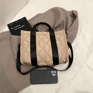 Sac fourre-tout matelassé kaki avec sangle noire dans un style minimaliste