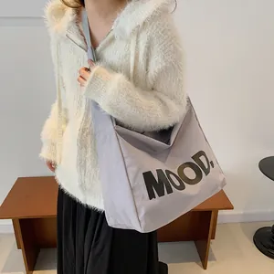 Grijze canvas draagtas met MOOD letteropdruk getoond op een model voor dagelijks gebruik
