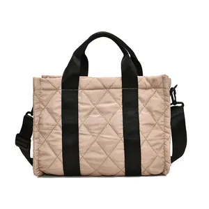 Sac fourre-tout beige matelassé avec lanières noires et bandoulière réglable