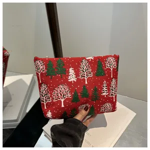 Gros plan de la pochette de Noël rouge avec motifs de sapins et fermeture éclair dorée