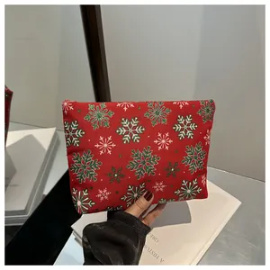 Gros plan d'une pochette de Noël rouge festive avec des motifs de flocons de neige