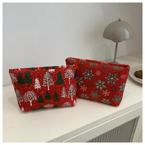 Détail de trousses de toilette rouges avec motifs de sapins de Noël et flocons de neige