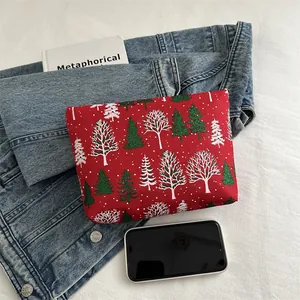Trousse à maquillage rouge en toile avec motifs de Noël sur fond de denim bleu
