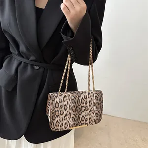 Fashionable leopard print shoulder bag with gold chain straps and a classic flap design