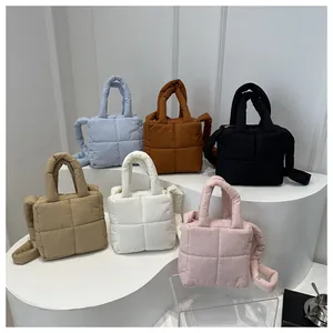 Quilted puffer tote bags in six colors arranged on a white platform in a studio