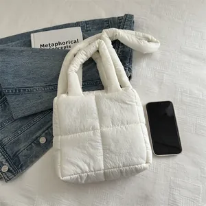 White quilted puffer tote bag with padded handles and square stitched pattern on fabric
