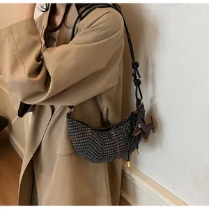 Detail der Crossbody-Tasche mit Hahnentrittmuster, Lederriemen und Dackel-Anhänger