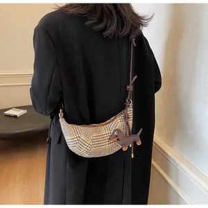 Rückansicht eines Models mit karierter Wolltasche und Dackel-Anhänger aus Leder für Damen