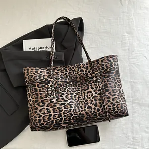 Chic leopard print large tote bag with leather texture, shown in a modern lifestyle scene