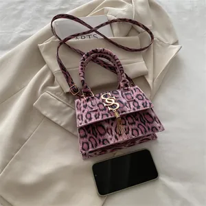 Mini sac à main rose imprimé léopard avec pompon et logo S doré sur veste beige