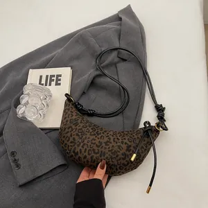 Detail der Croissant-Tasche mit Leopardenmuster, schwarzem Riemen und seitlichem Knotendetail