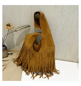 Close-up of tan suede tote bag with long bohemian fringes and soft texture