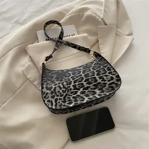 Chic leopard print underarm bag with gold hardware and spacious crescent moon silhouette