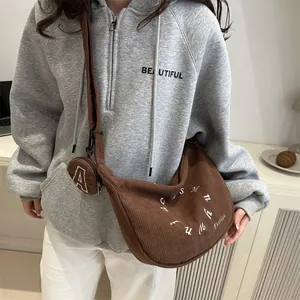 Brown corduroy large capacity tote bag with mini coin purse shown on a model
