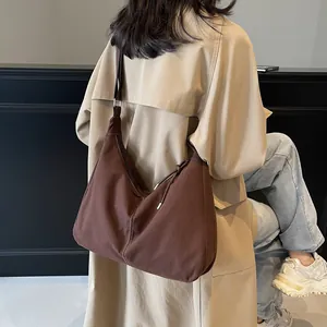 Bruine canvas hobo-tas met verstelbare schouderband en witte contraststiksels
