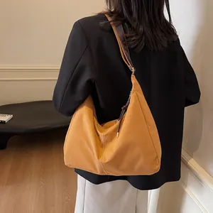 Chique vintage gembergele hobo schoudertas met leren riem getoond op een model