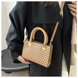 Dettaglio borsa a tracolla retrò con manici intrecciati e stampa moda sulla modella