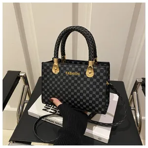 Dettaglio borsa tote nera con motivo a pois grigi e finiture metalliche dorate