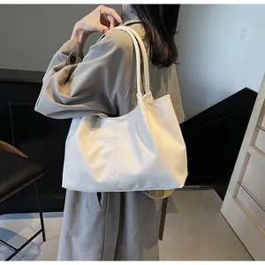 Detail of soft pleated white tote bag showing natural drape on shoulder in daily commute