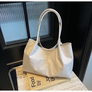 Detail view of cream pleated tote bag showing premium PU leather texture and shoulder straps