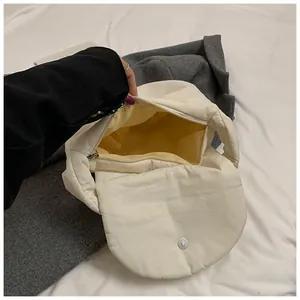 Detailed view of white padded handbag featuring bright yellow lining and metal zipper closure