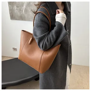 Detailed texture of brown lychee grain leather on a large tote bag for office wear