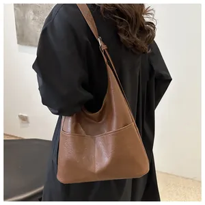 Macro detail of brown PU leather hobo bag showing soft texture and large outer pockets