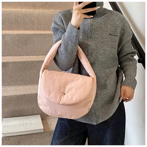 Detail of pink padded quilted tote bag featuring a minimalist metal snap button closure